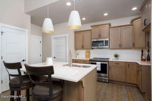 7257 Breaux Dr, Coeur Dalene, ID 83815 - kitchen with appliances with stainless steel finishes, a sink, tasteful backsplash, light countertops, and a textured ceiling