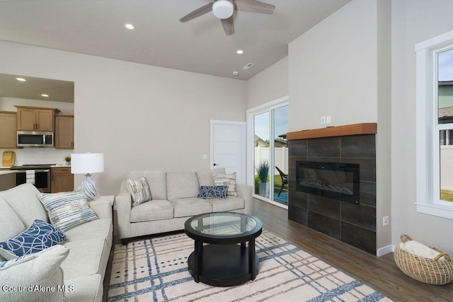 7257 Breaux Dr, Coeur Dalene, ID 83815 - living room with wood finished floors, a tiled fireplace, a ceiling fan, recessed lighting, and baseboards
