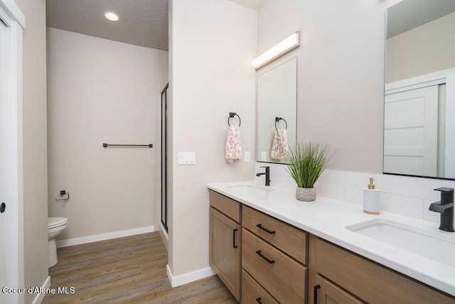 7257 Breaux Dr, Coeur Dalene, ID 83815 - full bath with wood finished floors, a stall shower, toilet, double vanity, and recessed lighting
