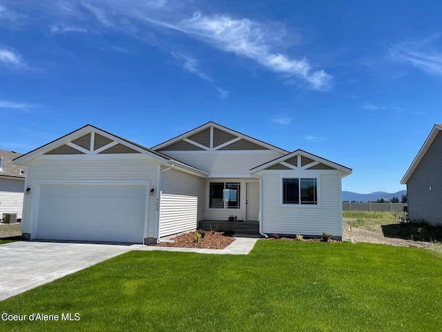 view of front of home with a front lawn, driveway, an attached garage, and a mountain view