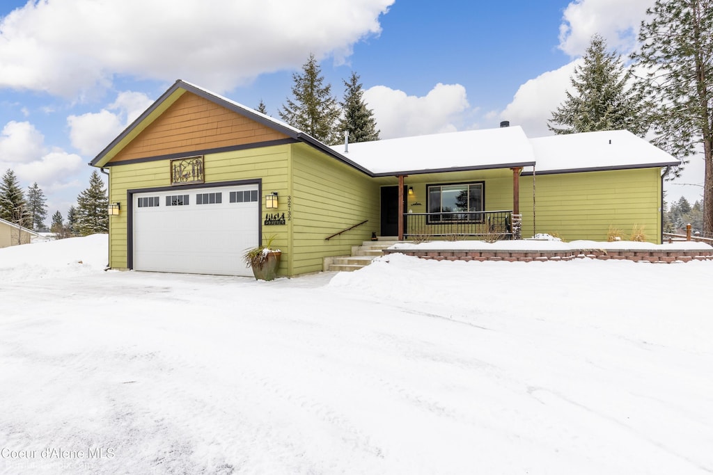 ranch-style house with a garage and covered porch