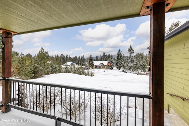 view of snow covered back of property