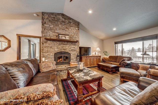 living room with a stone fireplace, high vaulted ceiling, and light wood-type flooring