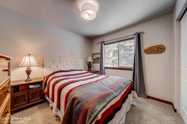 bedroom featuring light carpet and a textured ceiling