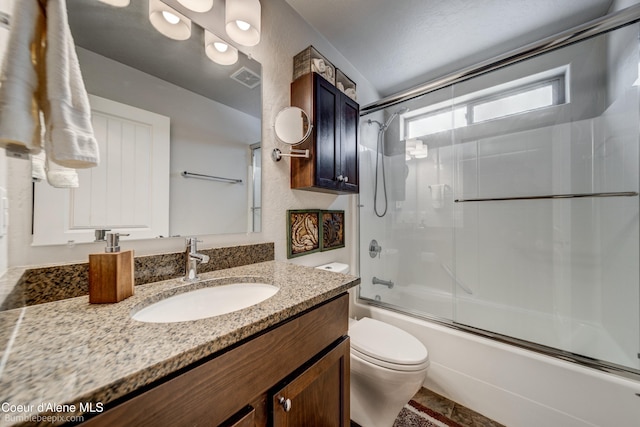 full bathroom with vanity, toilet, and combined bath / shower with glass door