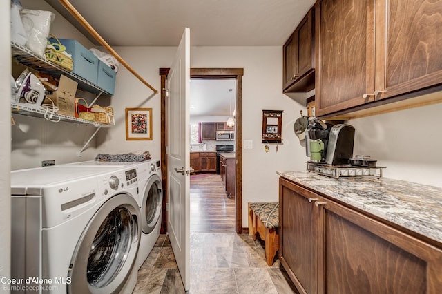 clothes washing area with cabinets and washing machine and clothes dryer