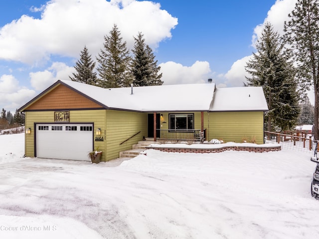 single story home featuring a porch and a garage