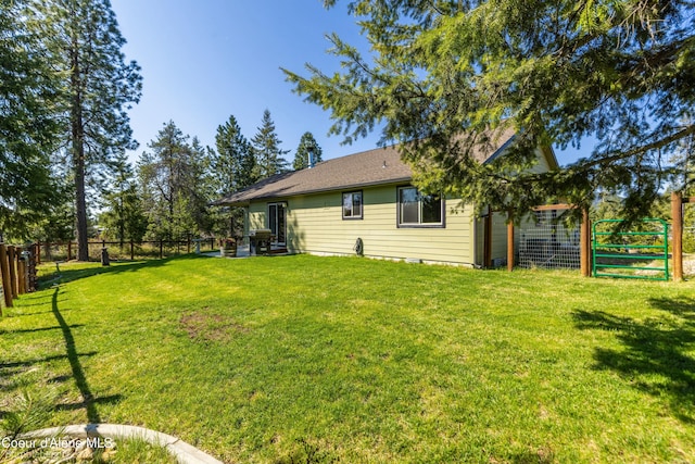 back of house with a yard and fence