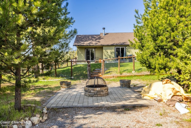 back of house featuring an outdoor fire pit, fence, a shingled roof, and a patio area