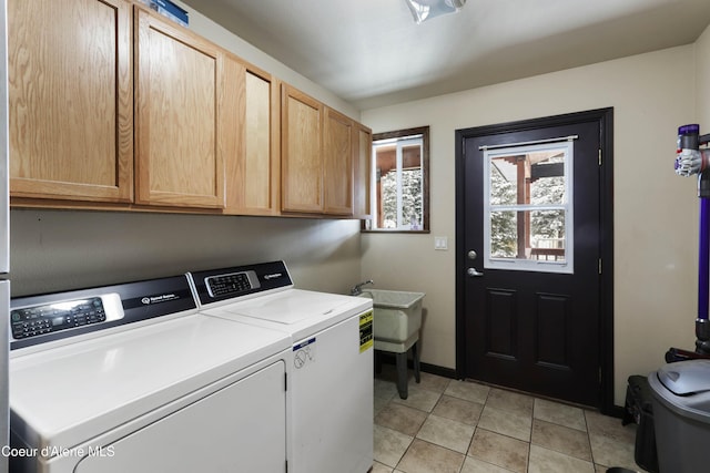 laundry room featuring separate washer and dryer, sink, light tile patterned floors, and cabinets