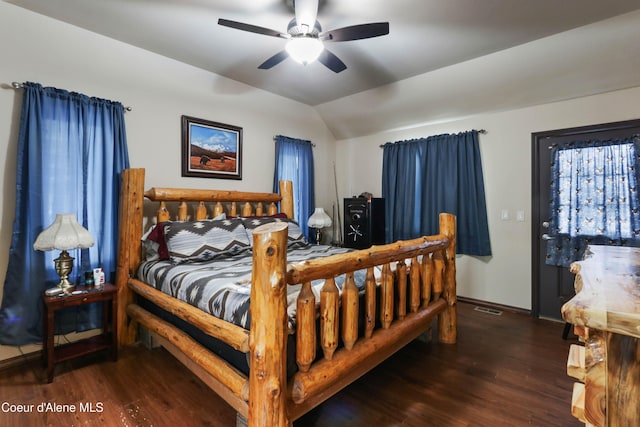 bedroom featuring dark hardwood / wood-style flooring, vaulted ceiling, and ceiling fan