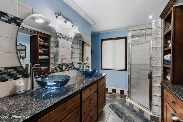 bathroom featuring decorative backsplash, tile patterned flooring, vanity, an enclosed shower, and crown molding