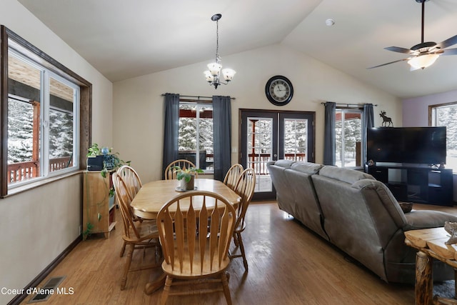 dining room featuring french doors, wood-type flooring, ceiling fan with notable chandelier, and vaulted ceiling