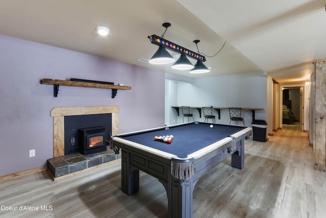 game room with wood-type flooring and bar area