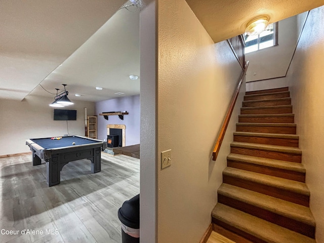 stairs with hardwood / wood-style floors and pool table