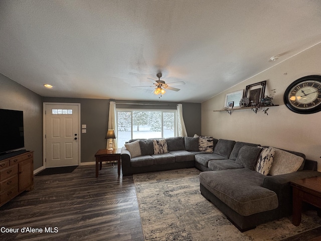 living room featuring ceiling fan, lofted ceiling, dark hardwood / wood-style flooring, and a textured ceiling