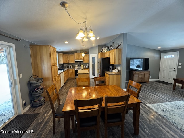 dining area with vaulted ceiling, dark hardwood / wood-style floors, and a chandelier