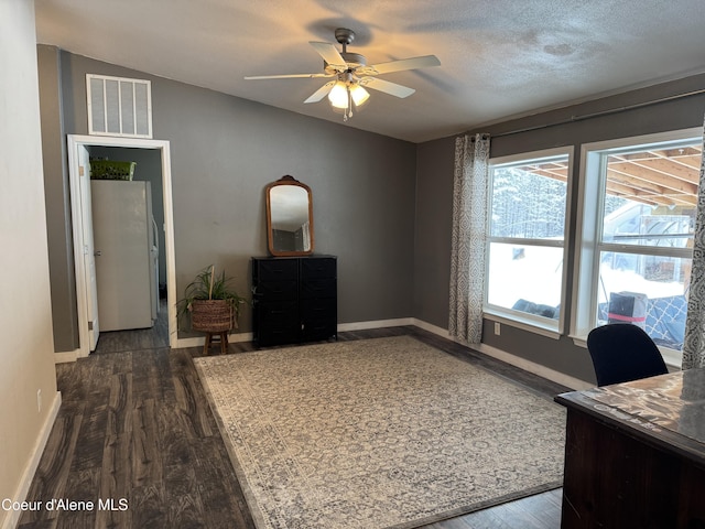 office featuring dark hardwood / wood-style flooring, a textured ceiling, lofted ceiling, and ceiling fan