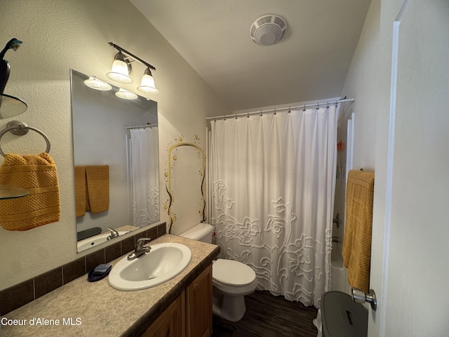 full bathroom with vanity, wood-type flooring, toilet, and shower / tub combo with curtain