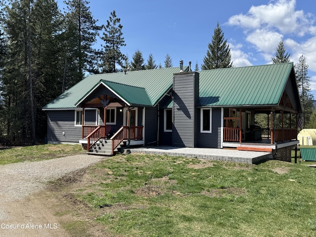 4058 W Seasons Rd, Rathdrum, ID 83858 - view of front of house with a chimney, metal roof, a front yard, and covered porch