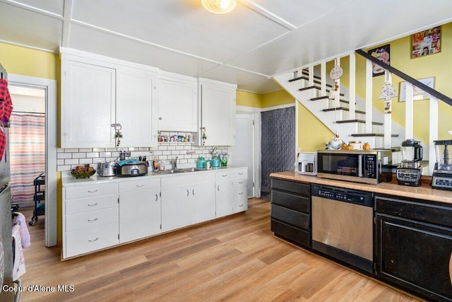 kitchen featuring white cabinetry, tasteful backsplash, appliances with stainless steel finishes, and light hardwood / wood-style flooring