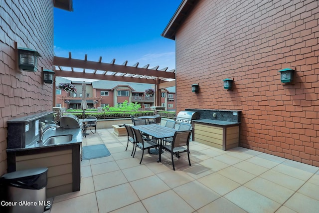 view of patio / terrace featuring area for grilling, sink, a pergola, and an outdoor kitchen