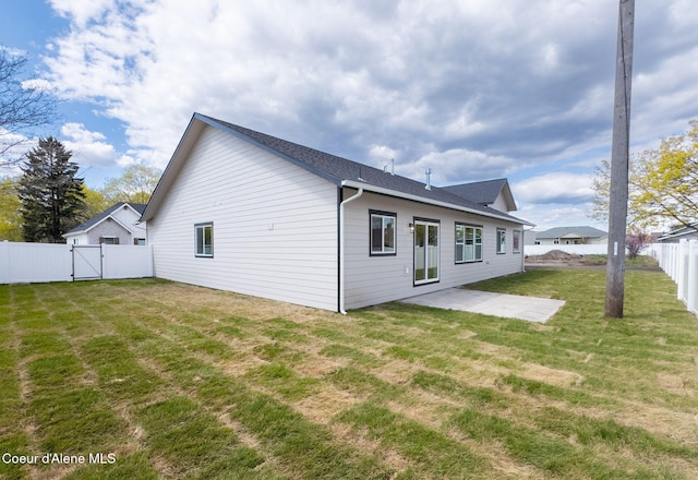 1225 W Orchard Ave, Hayden, ID 83835 - back of house with a gate, a fenced backyard, a yard, a patio area, and roof with shingles