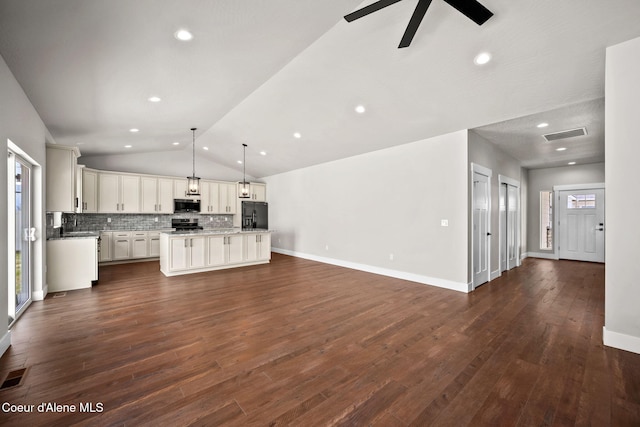 1225 W Orchard Ave, Hayden, ID 83835 - unfurnished living room featuring a ceiling fan, vaulted ceiling, dark wood-style flooring, and visible vents