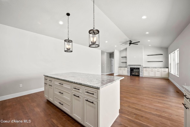 1225 W Orchard Ave, Hayden, ID 83835 - kitchen featuring lofted ceiling, ceiling fan, light stone counters, decorative light fixtures, and a fireplace