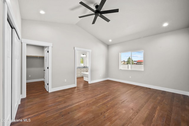1225 W Orchard Ave, Hayden, ID 83835 - unfurnished bedroom featuring dark wood-style flooring, vaulted ceiling, recessed lighting, a closet, and a walk in closet