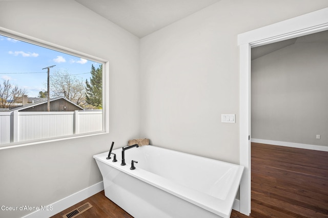 1225 W Orchard Ave, Hayden, ID 83835 - bathroom with a freestanding bath, wood finished floors, visible vents, and baseboards