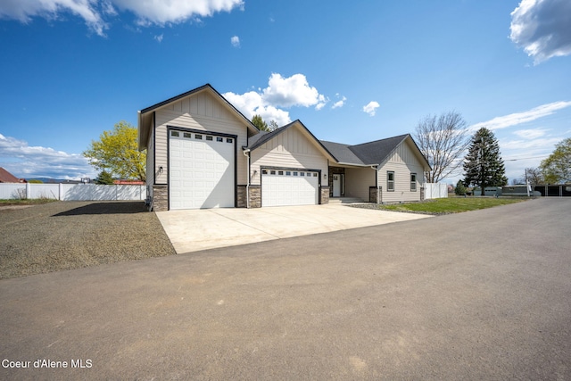 1225 W Orchard Ave, Hayden, ID 83835 - ranch-style home featuring driveway, stone siding, board and batten siding, fence, and a garage