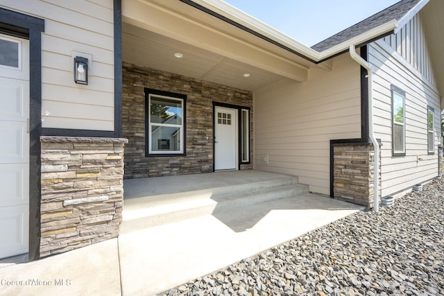 1225 W Orchard Ave, Hayden, ID 83835 - view of exterior entry featuring board and batten siding, a porch, stone siding, and roof with shingles