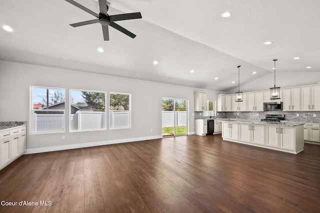 1225 W Orchard Ave, Hayden, ID 83835 - kitchen featuring stainless steel microwave, backsplash, vaulted ceiling, and open floor plan