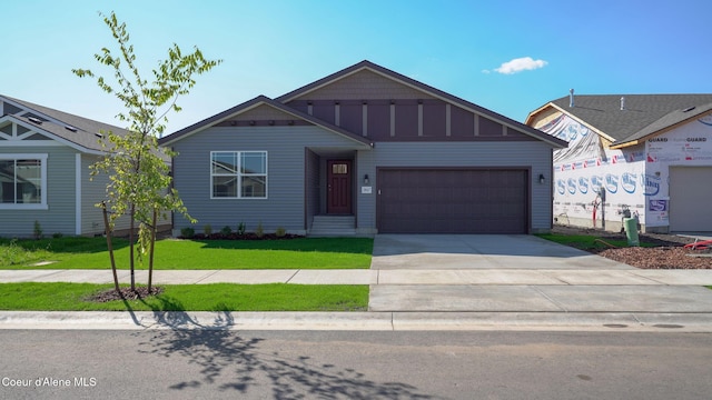 view of front facade with a garage, concrete driveway, board and batten siding, and a front yard