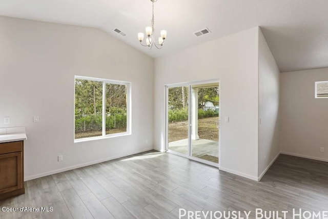 interior space featuring light wood-style floors, lofted ceiling, visible vents, and an inviting chandelier