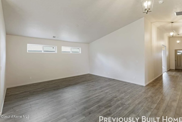 empty room with baseboards, visible vents, and wood finished floors