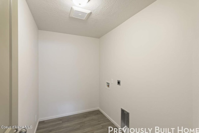 clothes washing area featuring washer hookup, dark wood-type flooring, a textured ceiling, laundry area, and baseboards