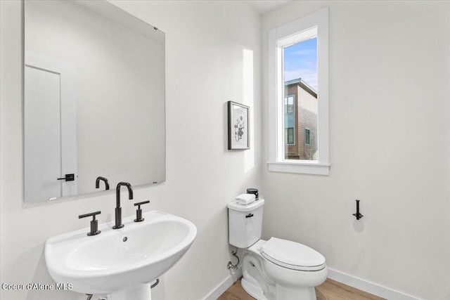 bathroom with toilet, sink, and hardwood / wood-style floors