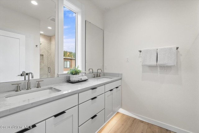 bathroom with vanity, hardwood / wood-style floors, and a shower with door