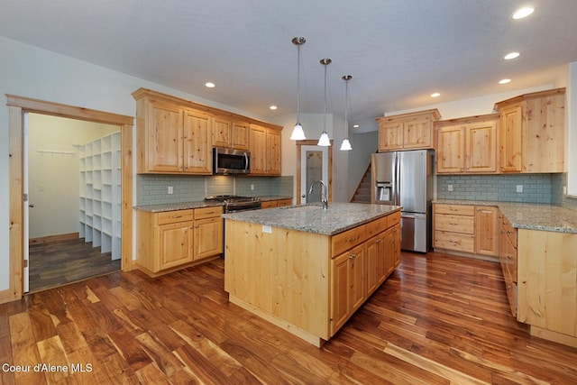 kitchen with appliances with stainless steel finishes, light brown cabinets, a sink, and dark wood-style floors