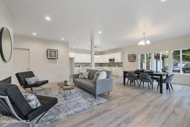 living room featuring a notable chandelier and light wood-type flooring