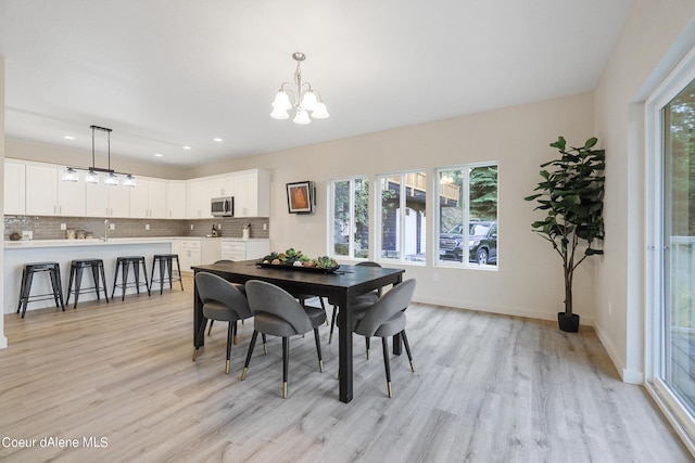 dining room featuring an inviting chandelier and light wood-type flooring