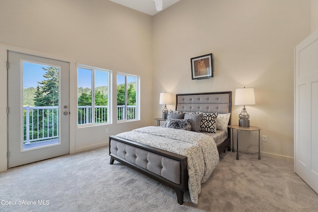 carpeted bedroom with a high ceiling and access to outside