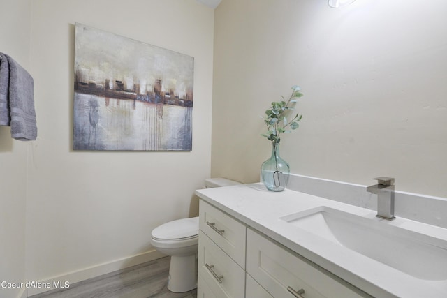 bathroom with vanity, hardwood / wood-style flooring, and toilet