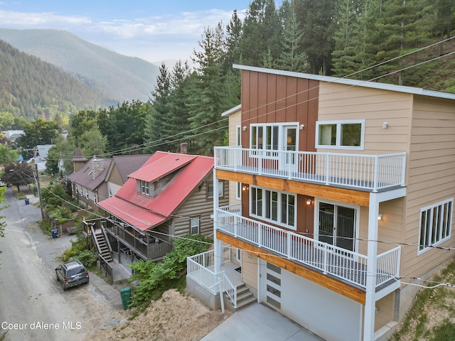 rear view of house featuring a balcony and a mountain view