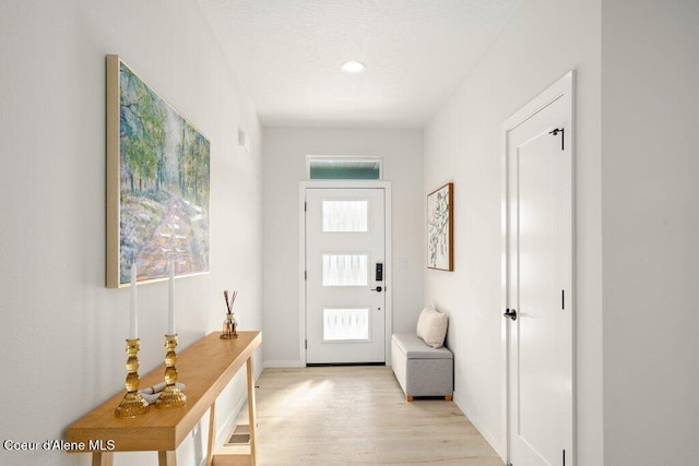 doorway with a healthy amount of sunlight, light wood-style flooring, and baseboards