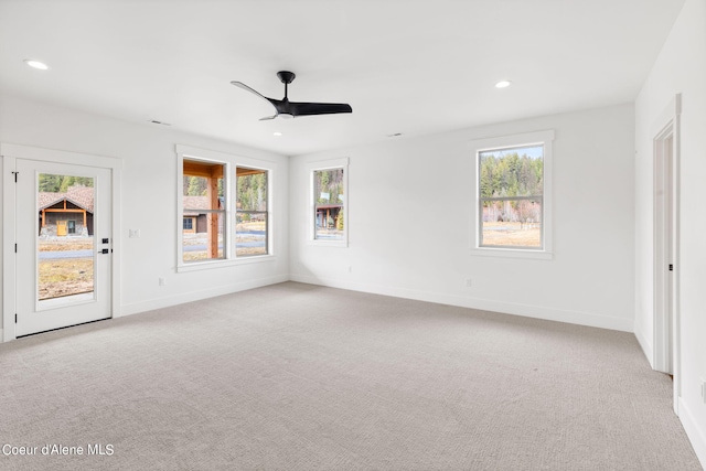 carpeted spare room featuring ceiling fan