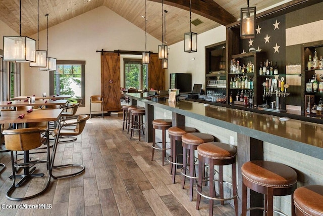 bar featuring wood ceiling, high vaulted ceiling, dark hardwood / wood-style flooring, pendant lighting, and a barn door