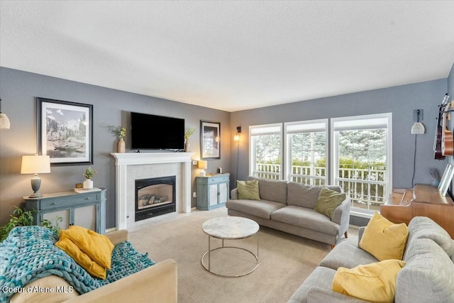 living room featuring a tiled fireplace, light carpet, and a textured ceiling